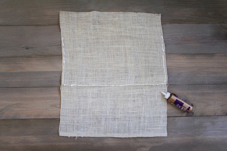 Burlap sheet with fabric glue on wood background