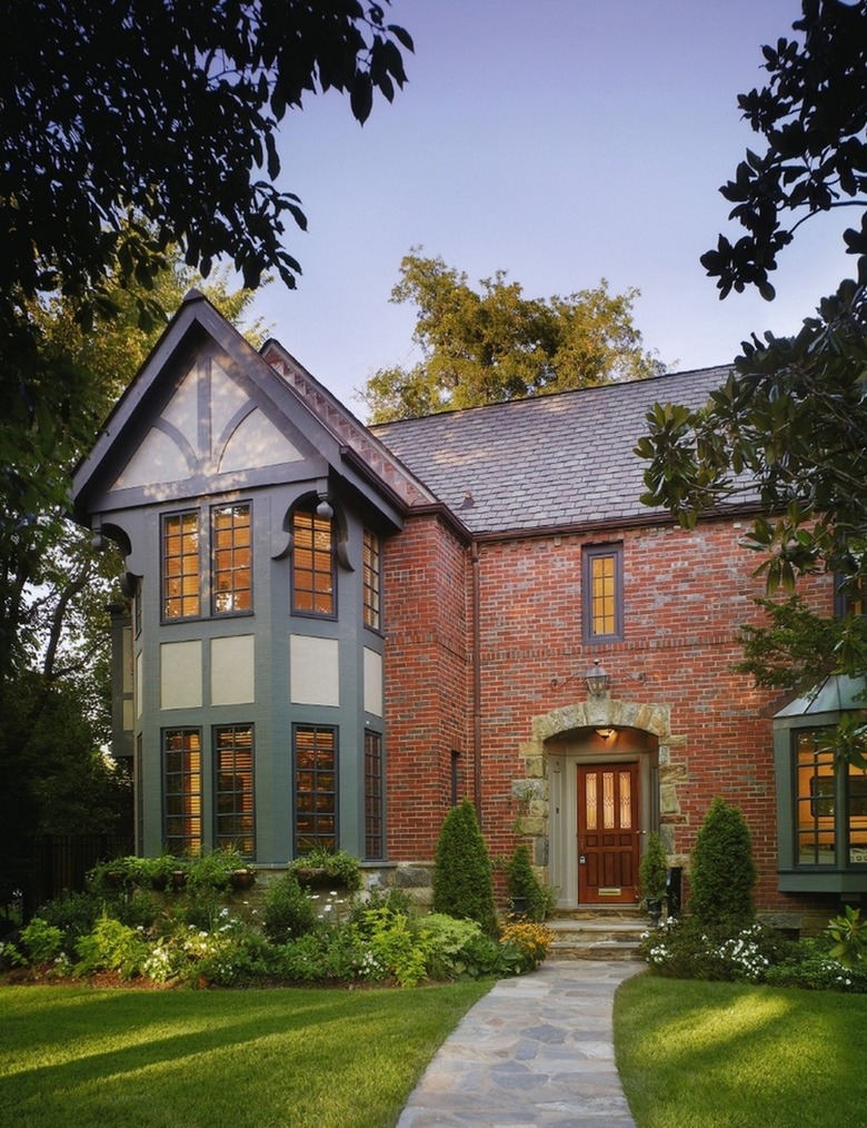 regal Tudor with green timbers and brick and stone facade