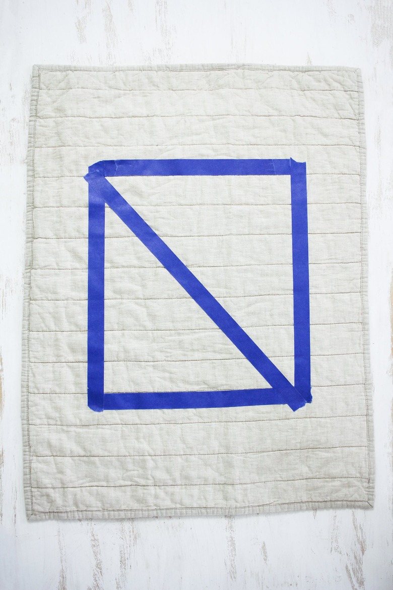 White quilted pillow with blue painters tape