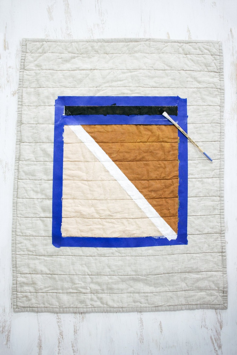 Quilted pillow shame with blue painters tape around brown