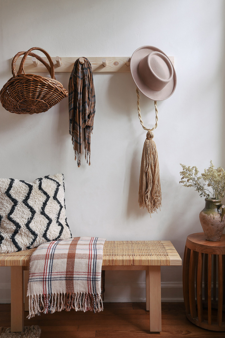 DIY wooden peg rail hanging above bench with baskets