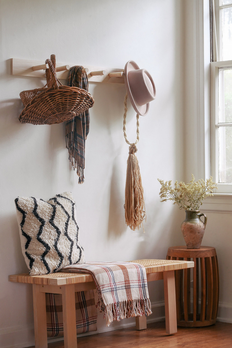 DIY wooden peg rail hanging above bench with baskets