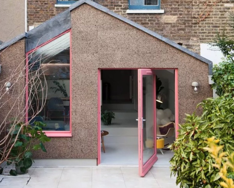 Exterior pivot door with pink trim.