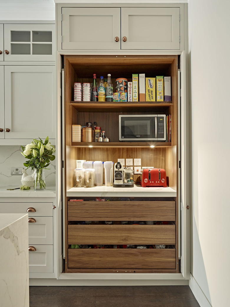 kitchen storage idea with built-in pantry closet with retractable doors and pull-out drawers