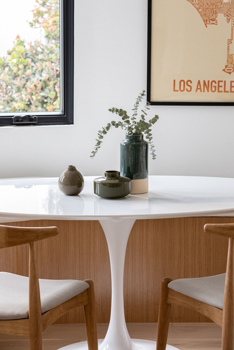 Modern dining room with white round table with plant