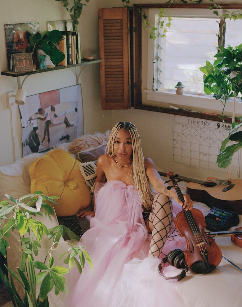 person in pink tulle dress sitting near window
