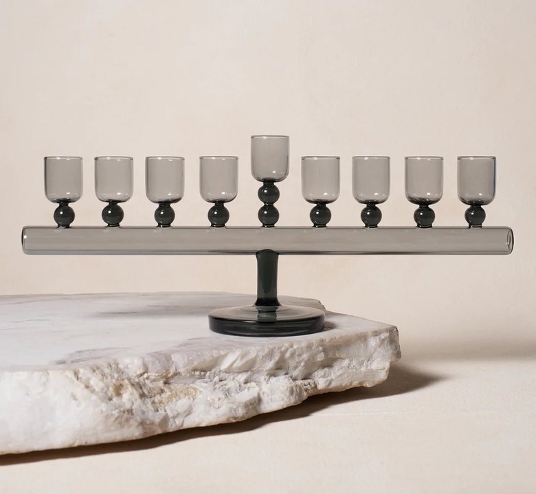 Glass Chanukiah in the color smoke with black and gray details on a gray stone.