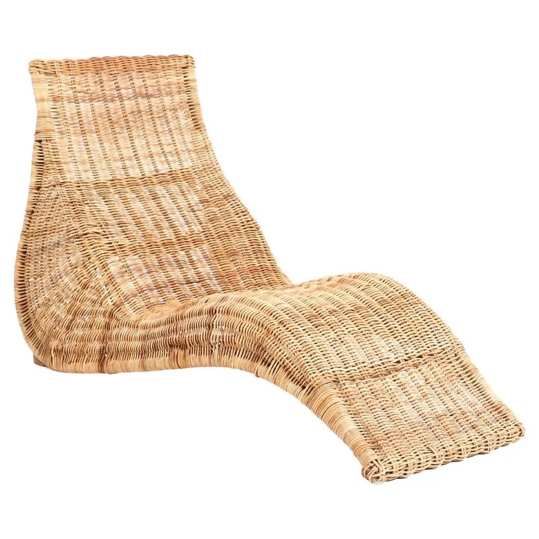 Long wicker lounge chair from IKEA with a curved bottom on a white background.