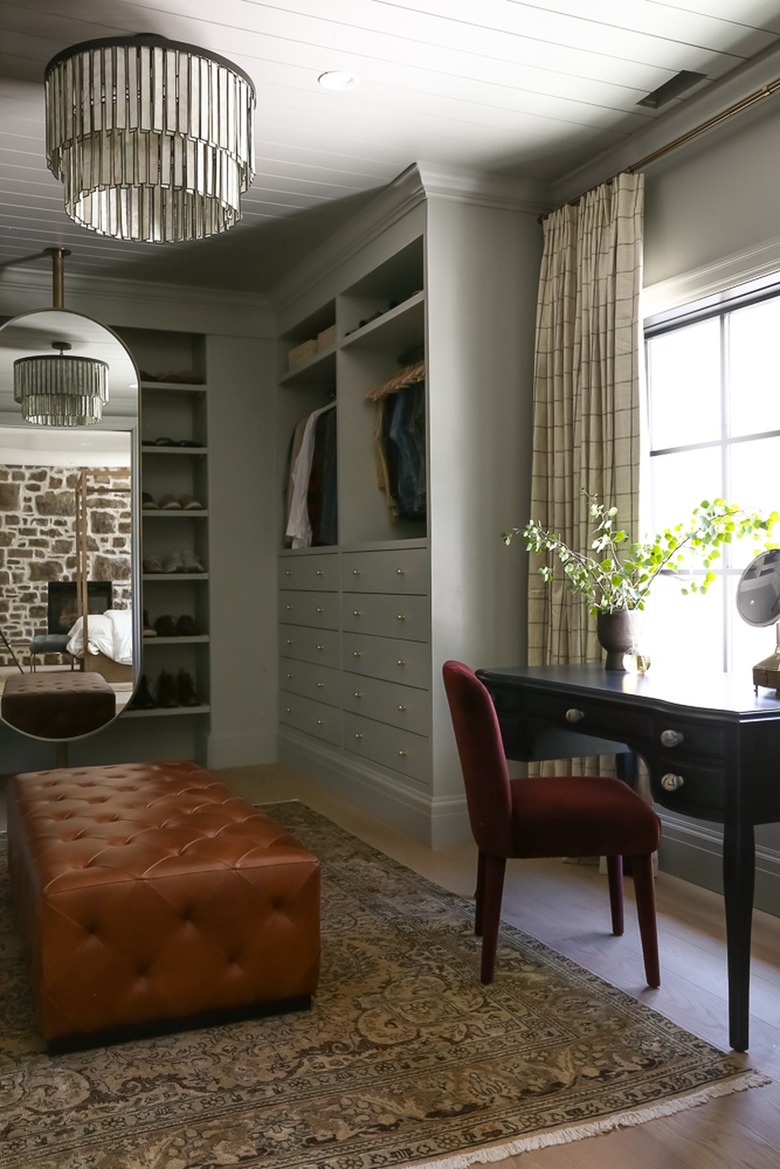 luxurious walk-in closet with leather ottoman