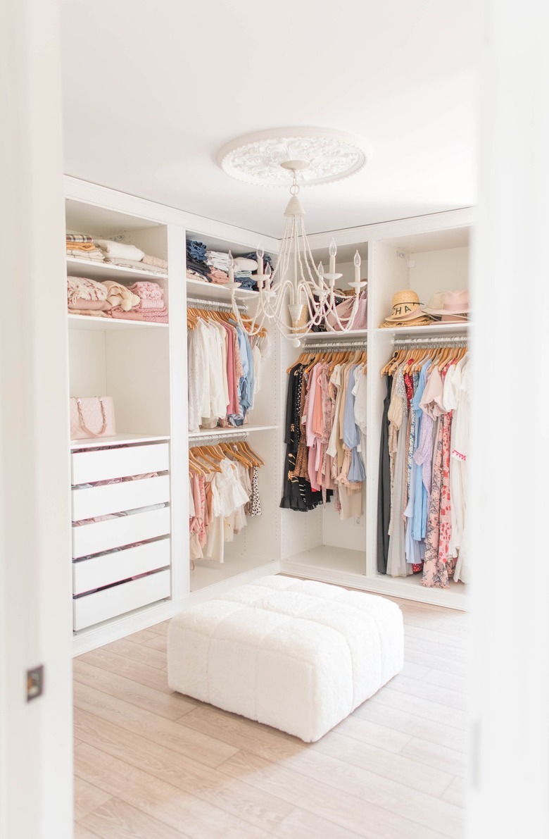 light and airy dressing room with boucle ottoman and chandelier