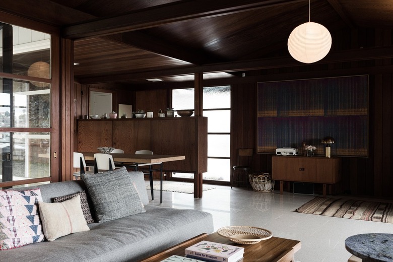 living room with dark bown wood furniture and dark brown wood walls