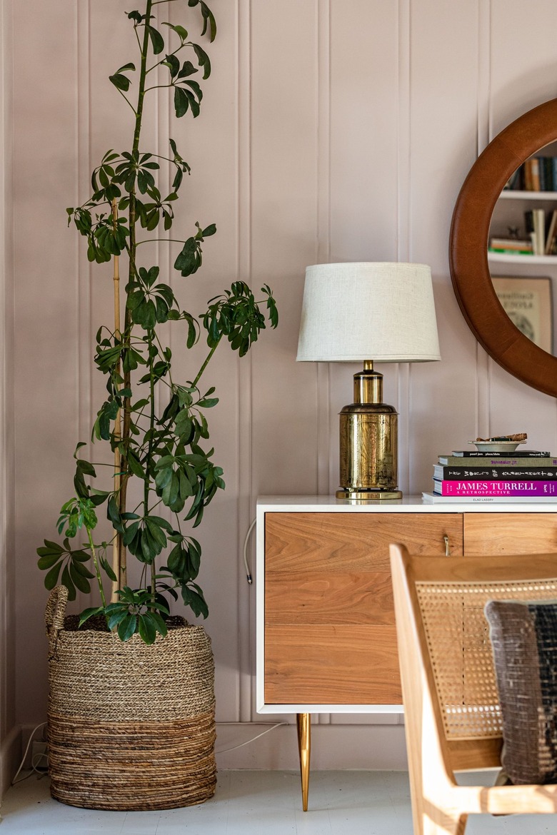 pink walls with brown furniture and plant in woven basket