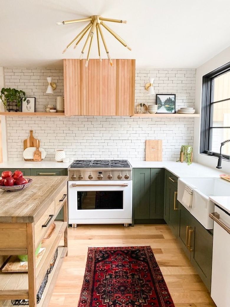 Kitchen with green cabinets and wood floors.