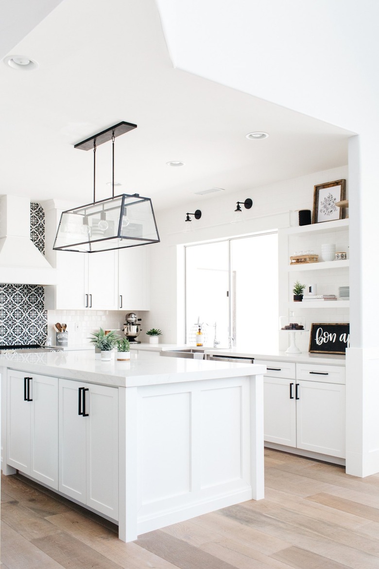 Kitchen with white cabinets and wood floors.