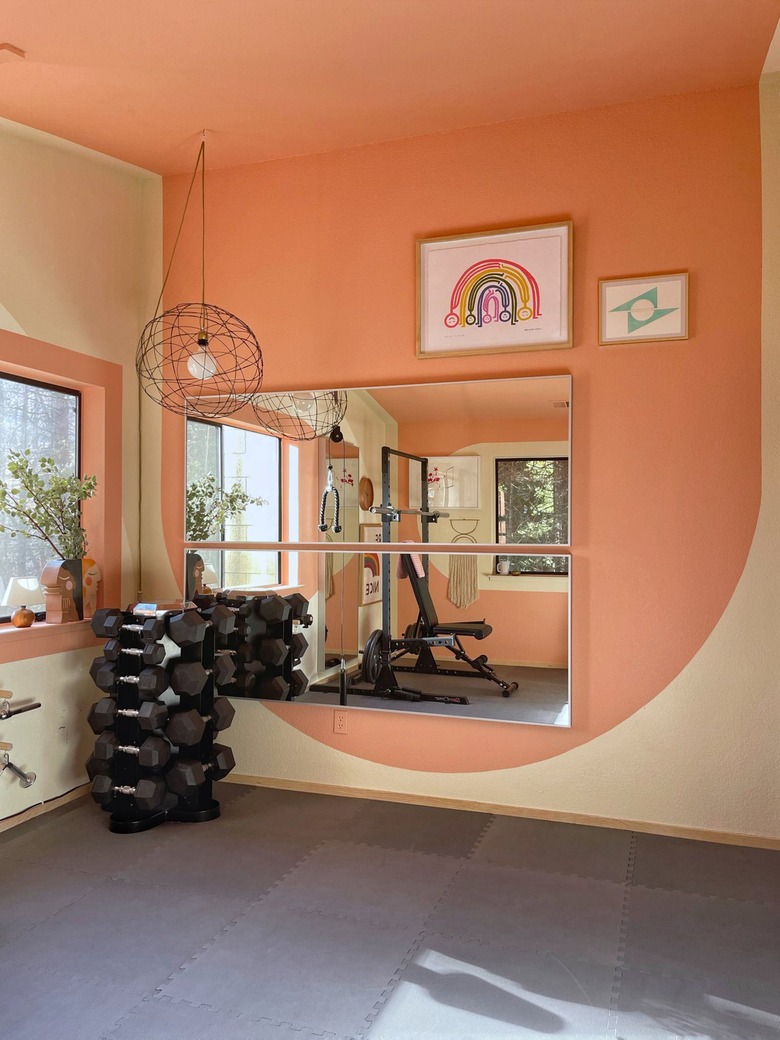 pink and white accent wall with artwork in home gym