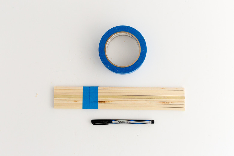 Tape the dowel rods together and mark the line where they need to be cut.