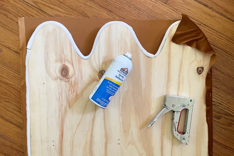 Upholstering one side of the wavy. bench arms by stapling foam