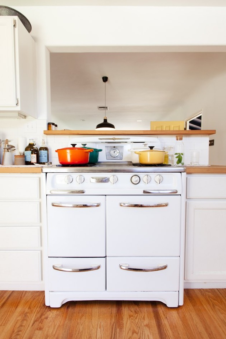 White oven with colorful pots on the stovetop