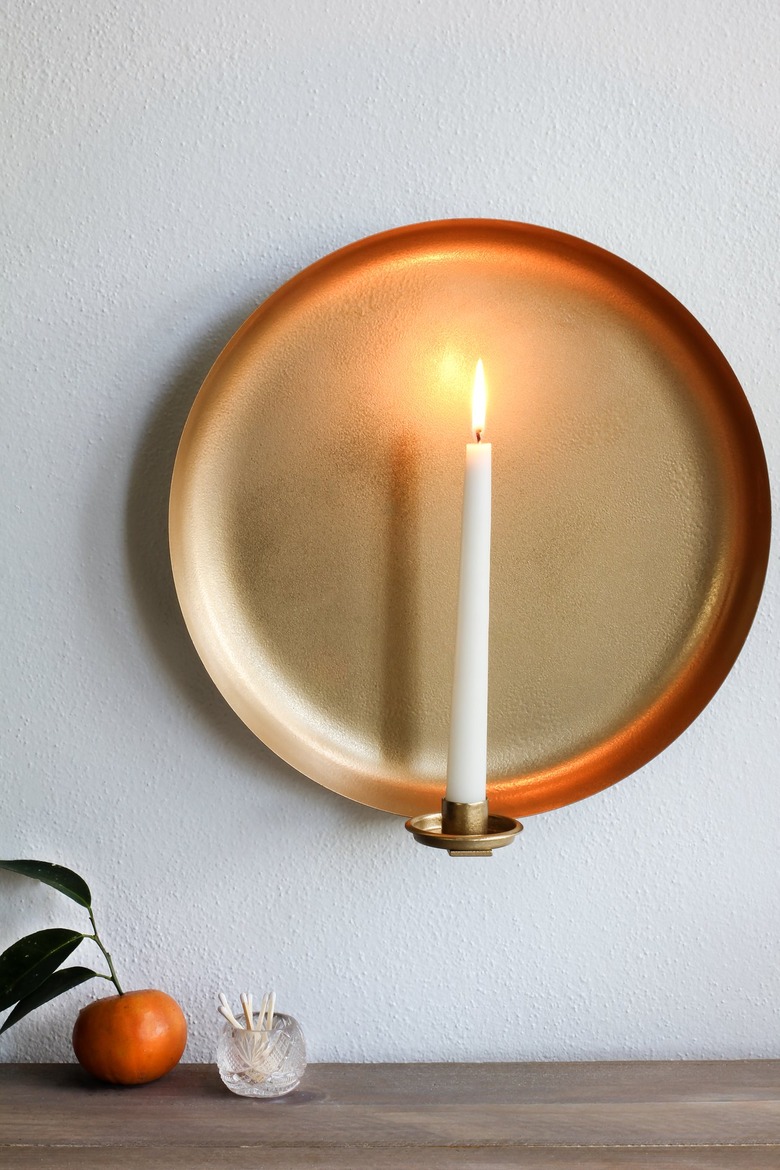 Round wall sconce with tangerine and container of matches