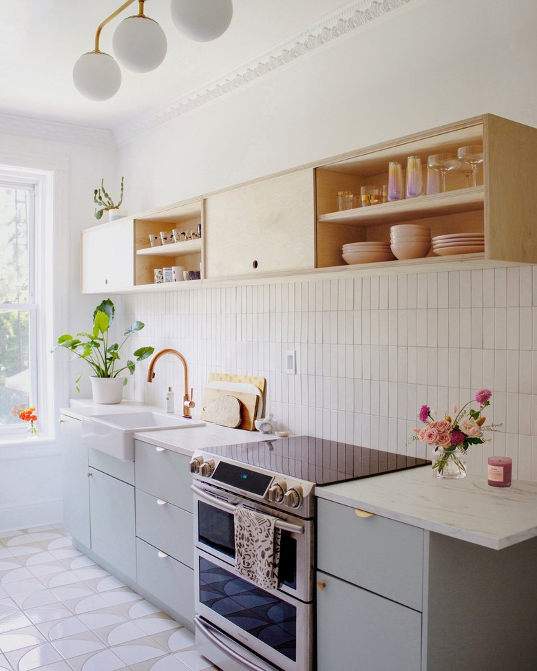 light wood shelving unit goes with sage green cabinets in kitchen