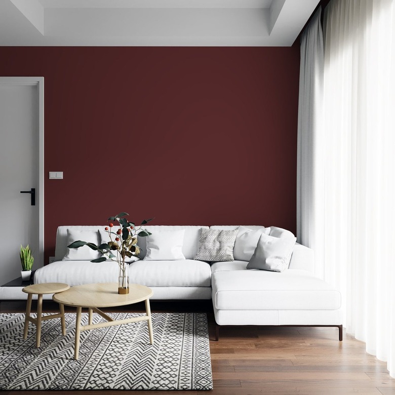 Living room with red accent wall and gray patterned rug