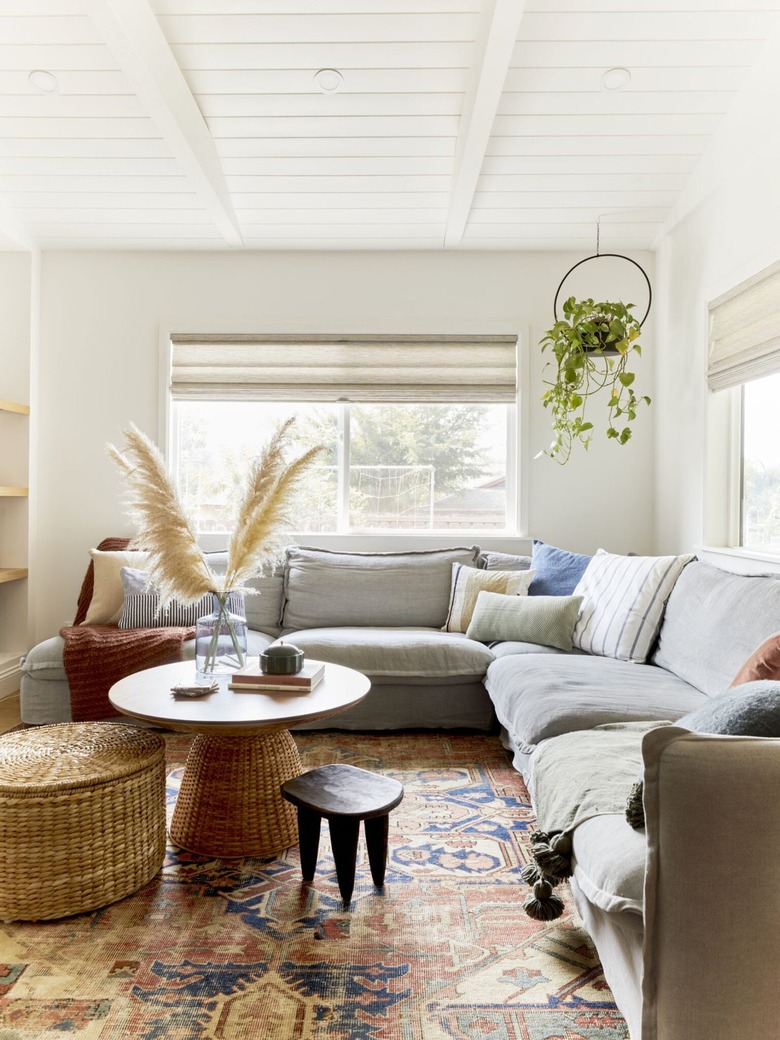 Gray couch with rust and royal blue patterned rug