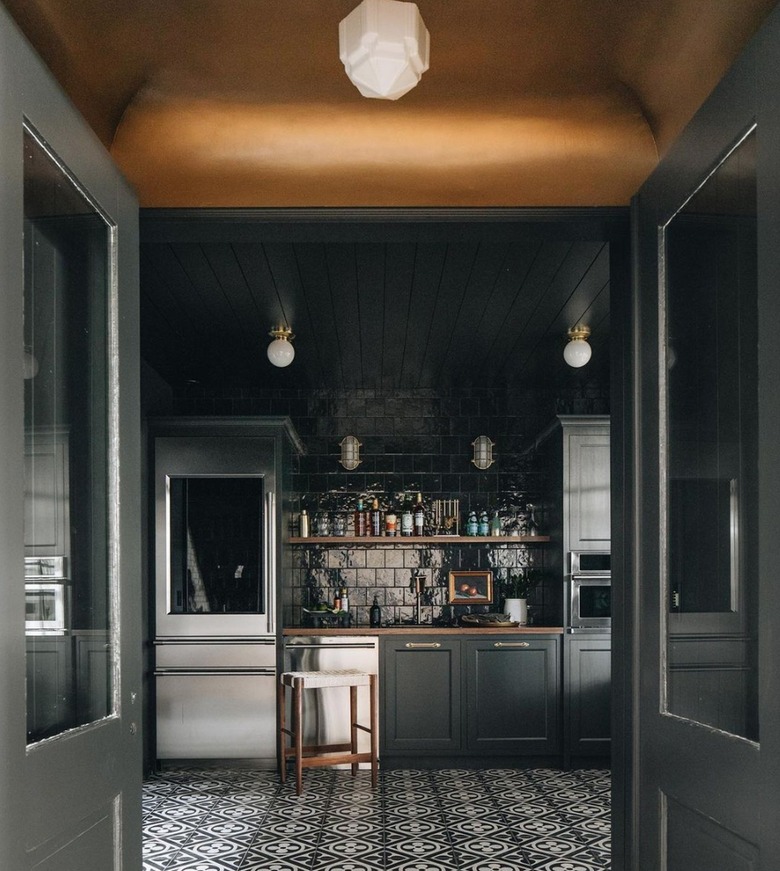 Kitchen with dark gray cabinets and black walls.