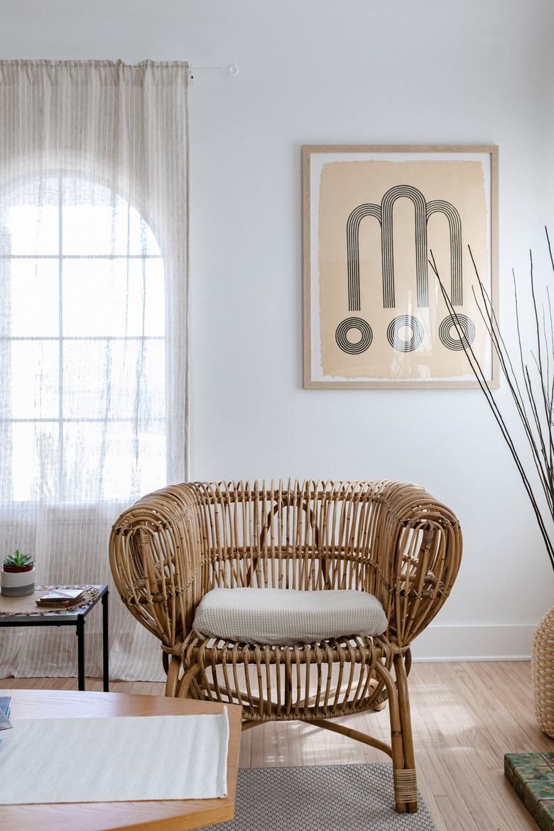 A white walled living room with boho furniture and accents