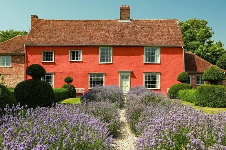 Orange cottage with red tile roof and garden and stone walkway