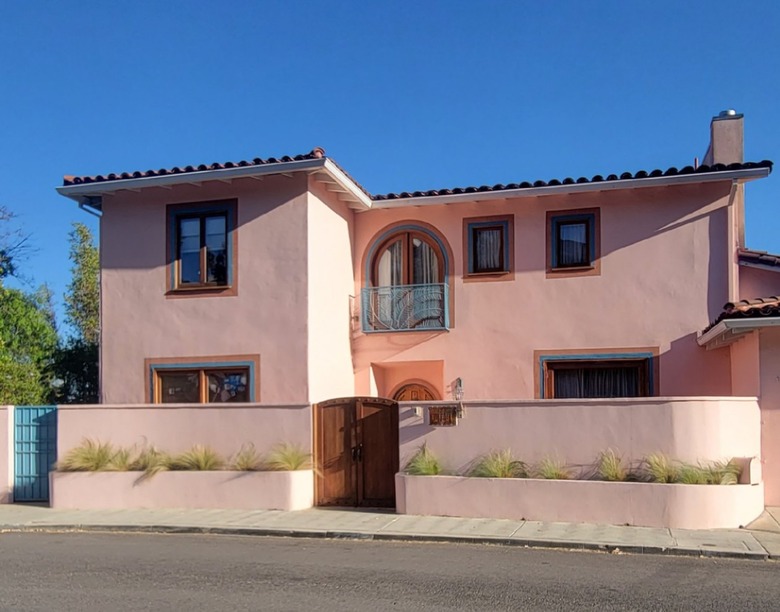 Coral Spanish style home with teal trim and red tile roof