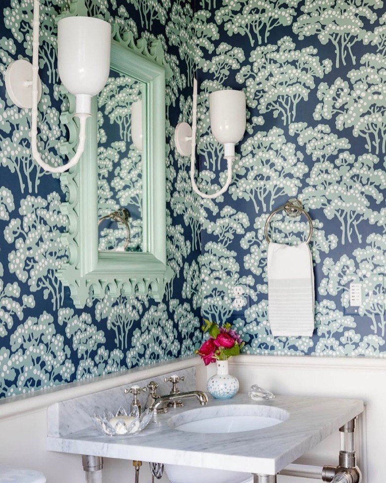 powder room with navy and mint green botanical wallpaper and mint mirror frame