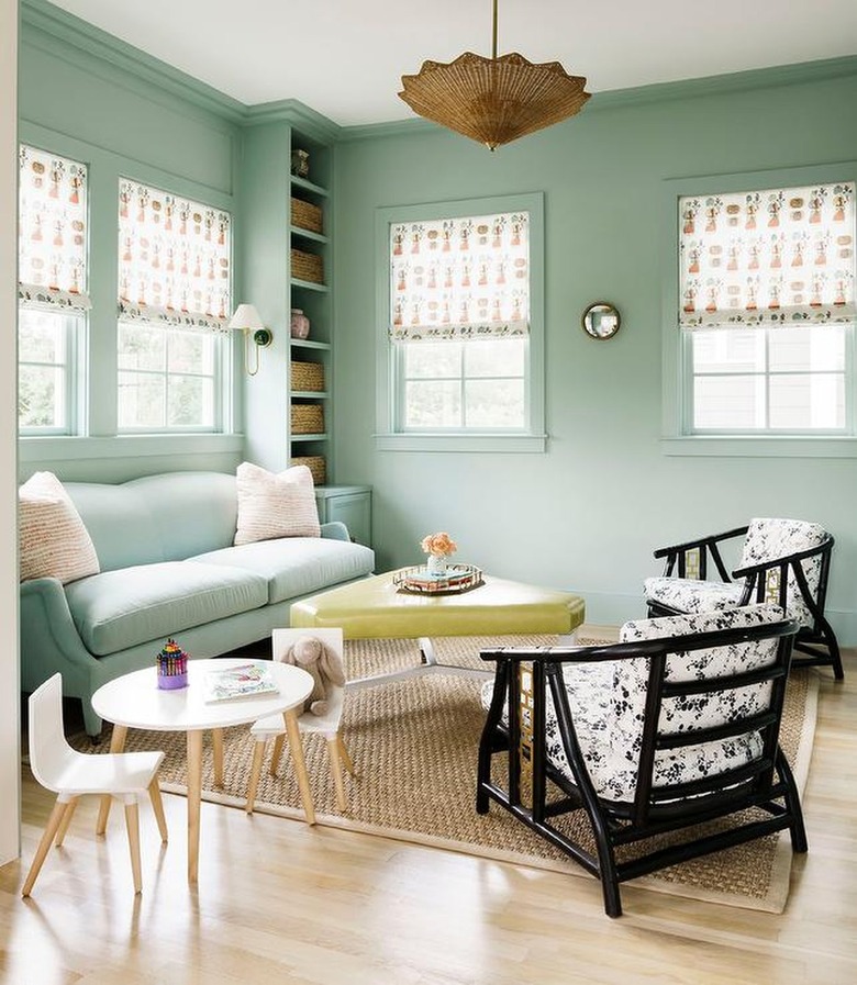 mint green living room with black chairs and pear green ottoman