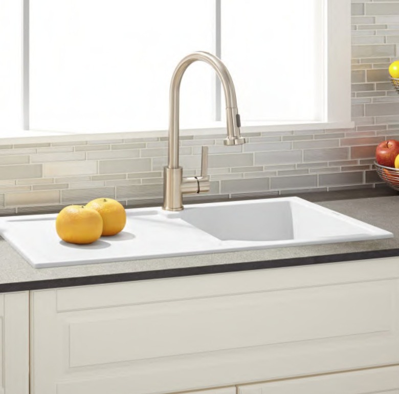 White single basin drop-in drainboard kitchen sink with faucet.