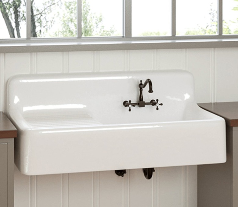 White cast iron wall mounted sink with drainboard.