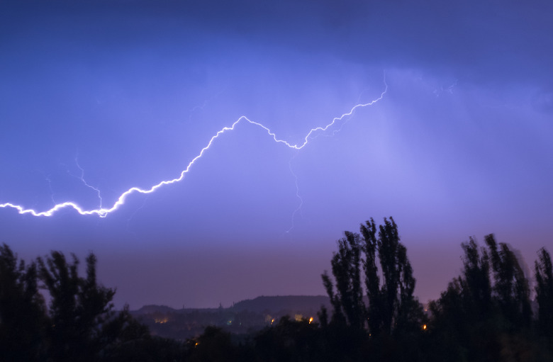 Night lightning storm over city in blue dramatic lighting