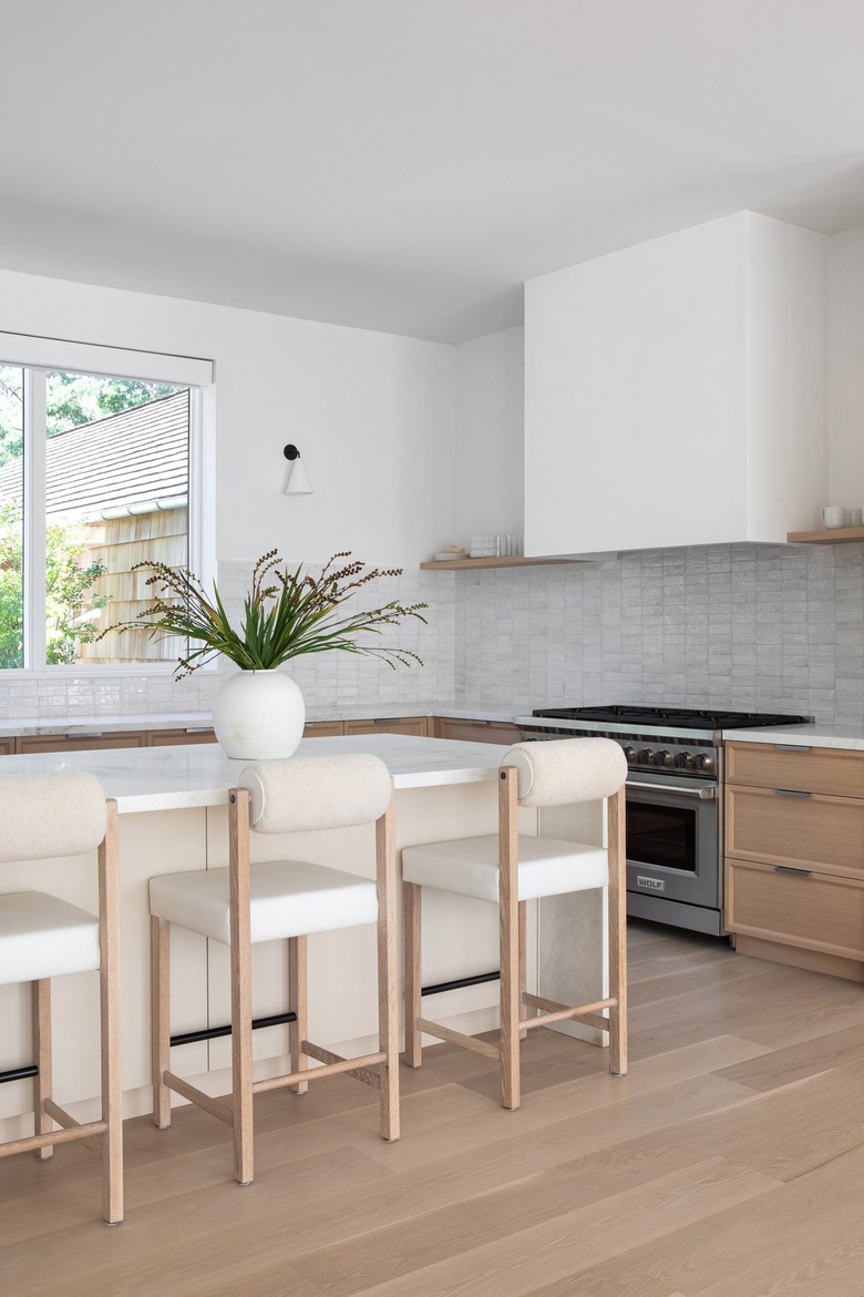 white kitchen with bouclé barstools at island