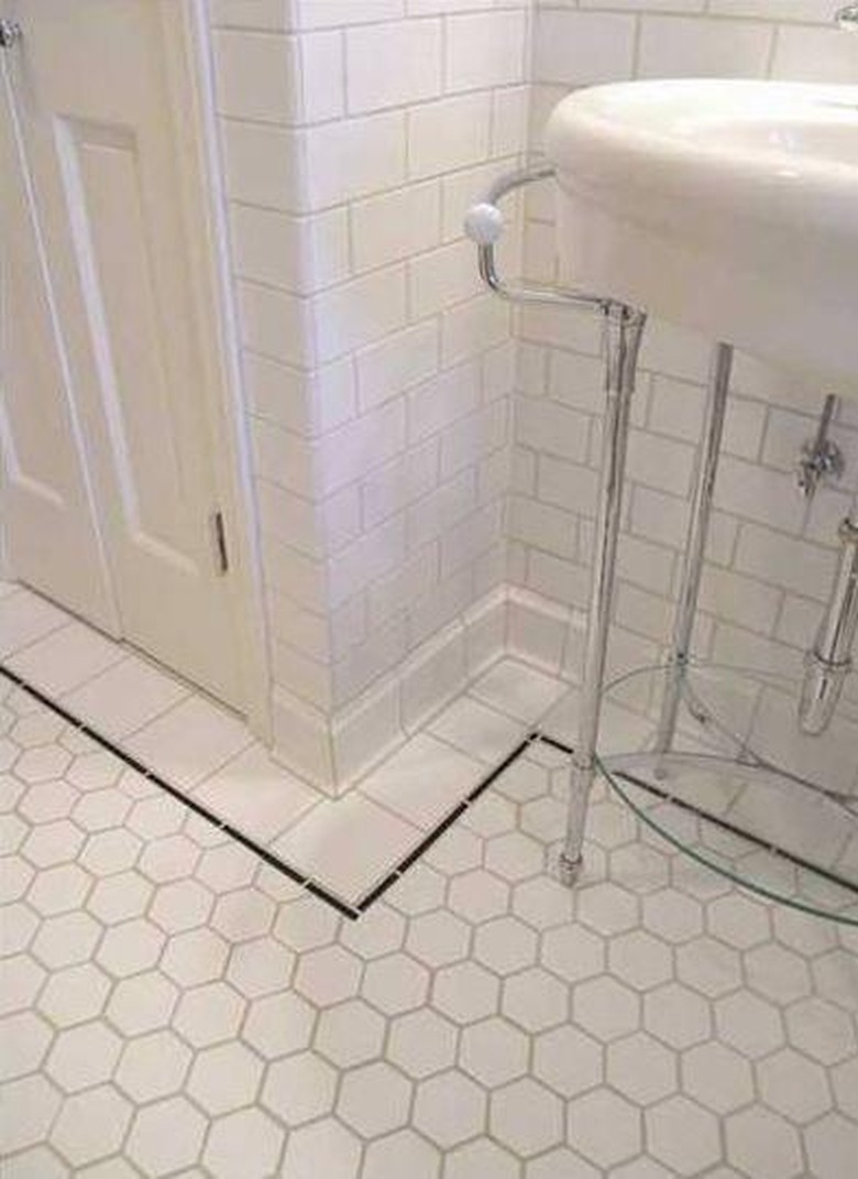 white sanitary cove base tile in white tiled bathroom black tile trim
