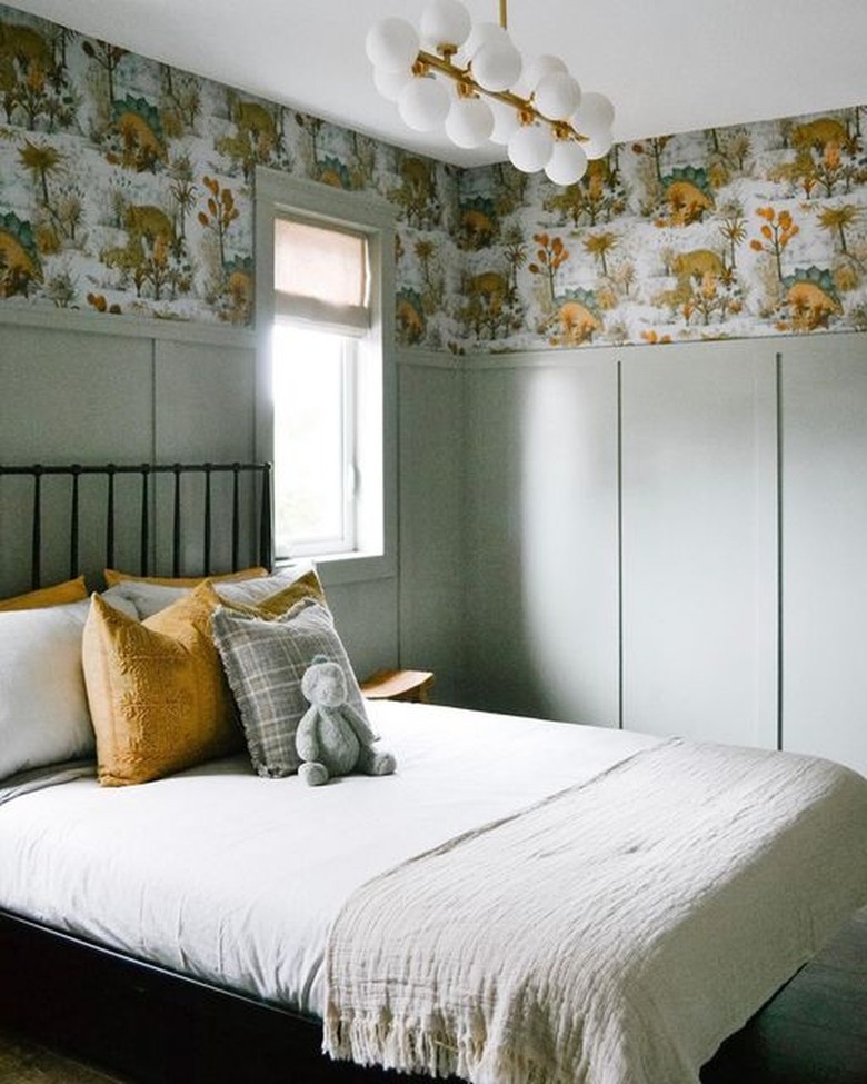 boys bedroom with sage green wall paneling and yellow dinosaur wallpaper
