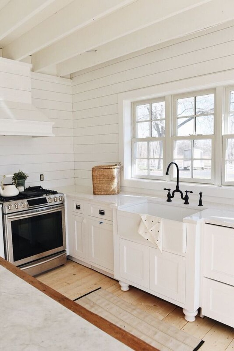 White farmhouse kitchen with white shiplap backsplash.