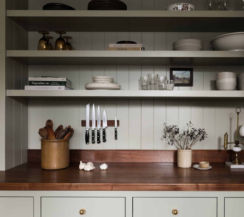 Olive green kitchen cabinets with wood counters and olive green shiplap