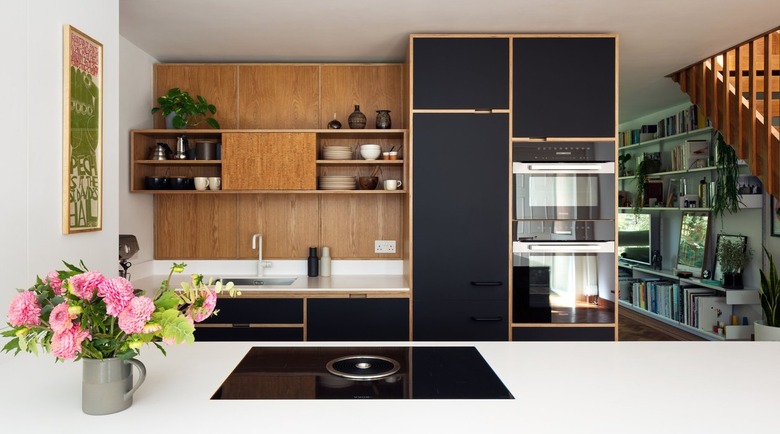 Modern kitchen with black cabinets and wood backsplash