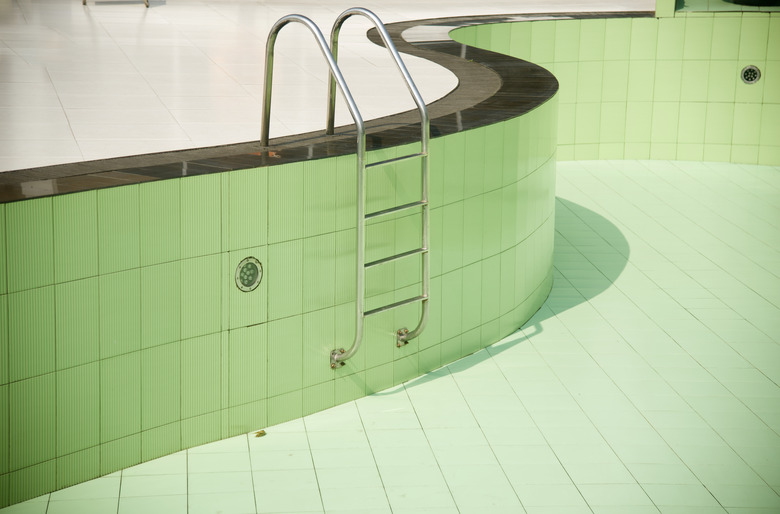 An empty swimming pool with metallic stairs