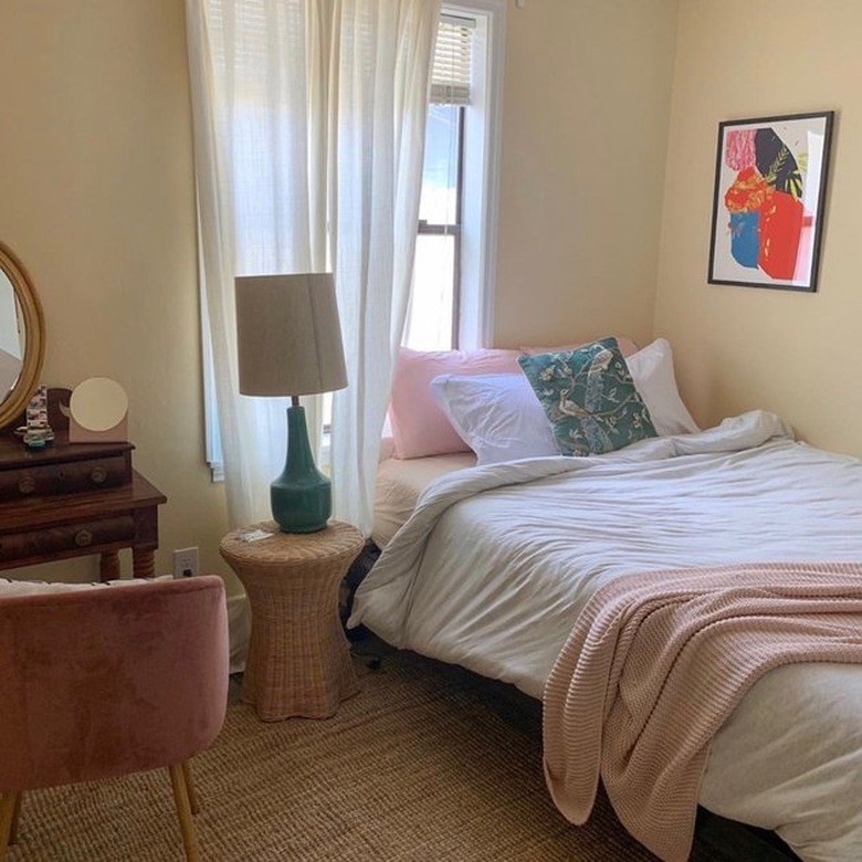 bedroom with pink and white bed and framed artwork