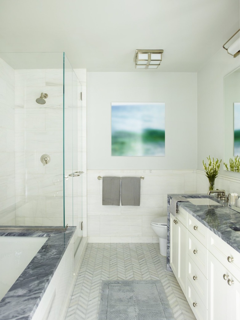 white bathroom with dark marble counters and chevron tile floor