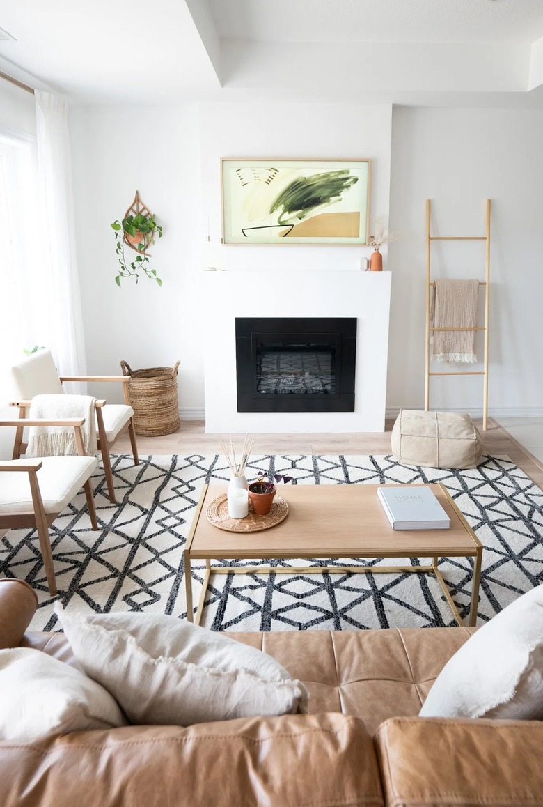 white living room with modern artwork above fireplace
