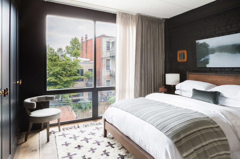 bedroom with exposed brick wall painted black