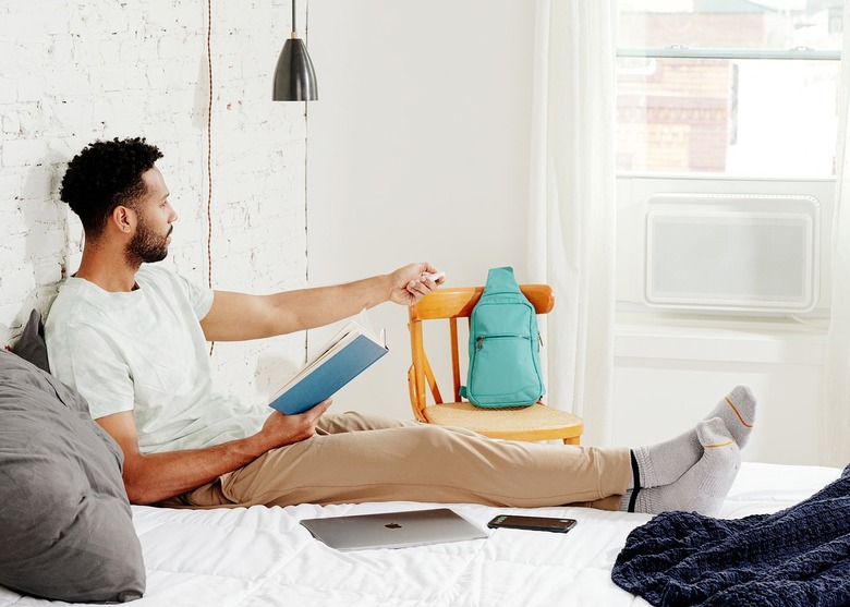 man in bed with windmill ac in window