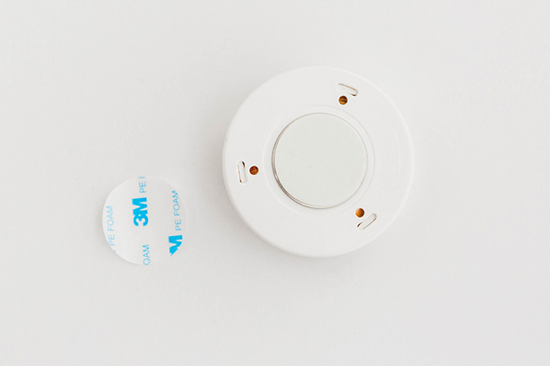 Peel the backing paper off the sticky magnet.