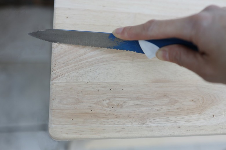 Slicing and scratching wood surface with a serrated knife