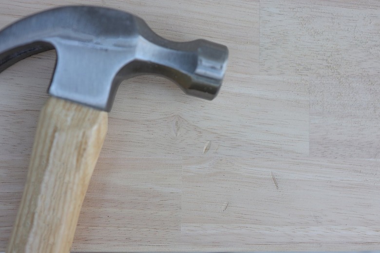 Dents and dings made in wood surface with a hammer